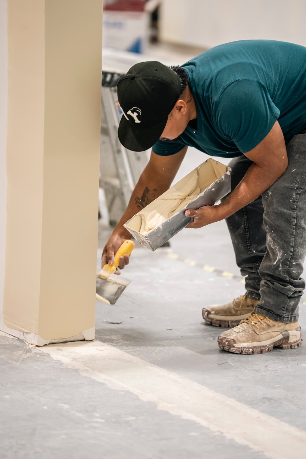 Finisher applying joint compound to a drywall column during a commercial renovation